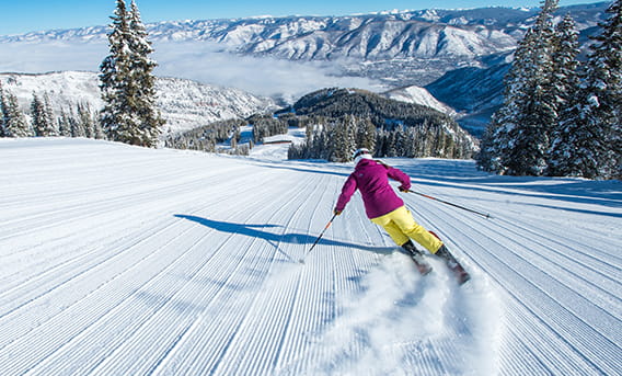 A skier skiing down the fresh tracks on Aspen Mountain.