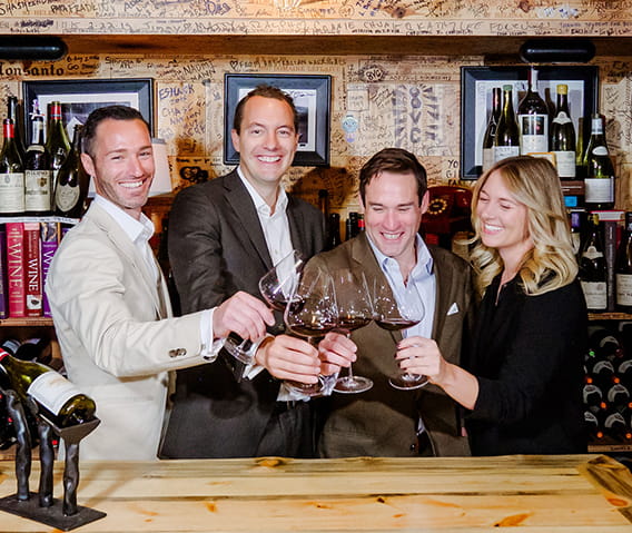 The Little Nell Sommelier Team toasting glasses of wine in The Little Nell Wine Cellar